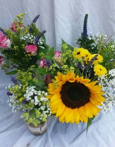 Jam jar arrangements for wedding reception tables, sunflowers and pink roses
